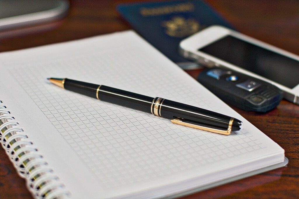 ChatGPT schreibt einen Brief mit Notizblock, Kuli und Handy